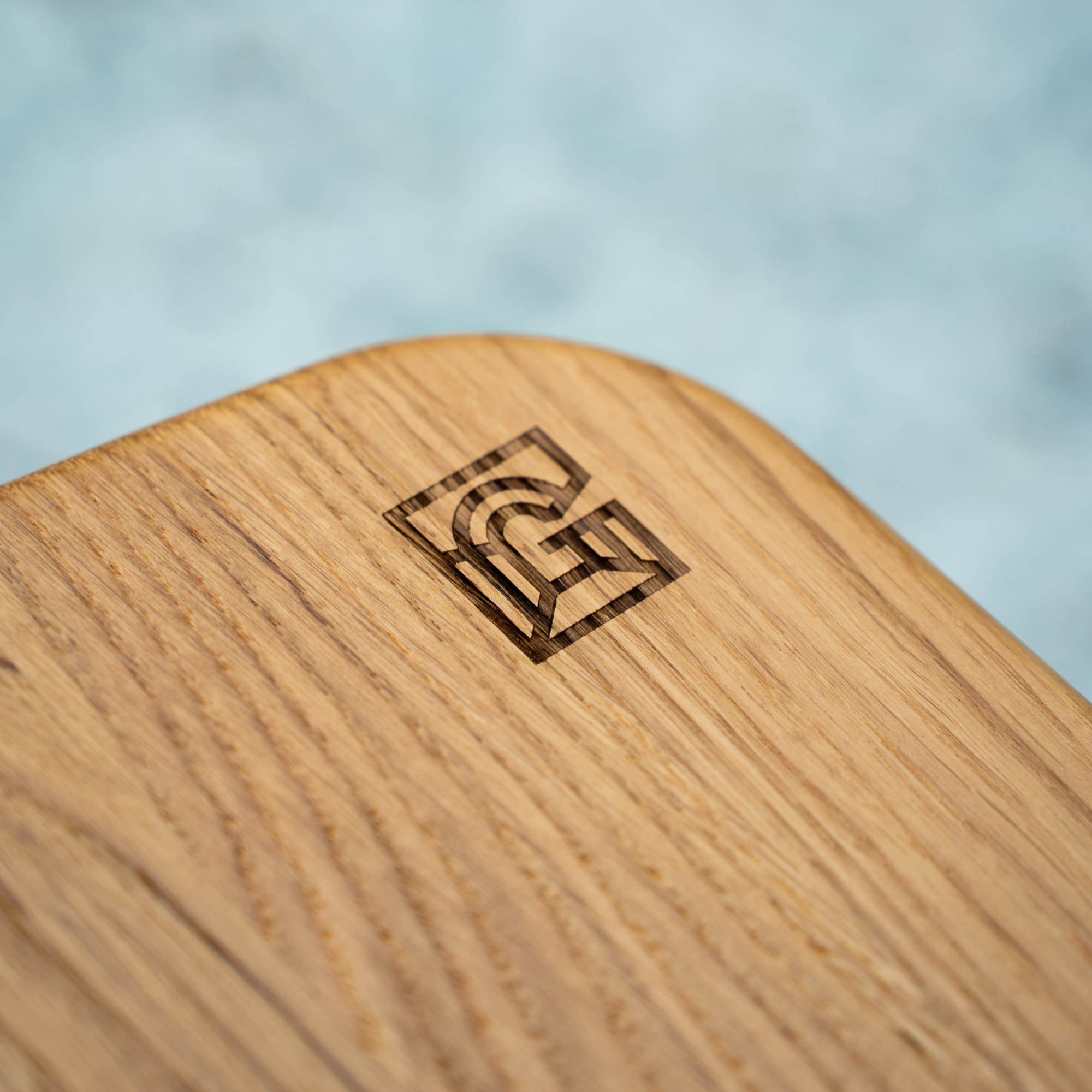 Detail of new Grainger Market furniture showing logo etched in to wooden seat.