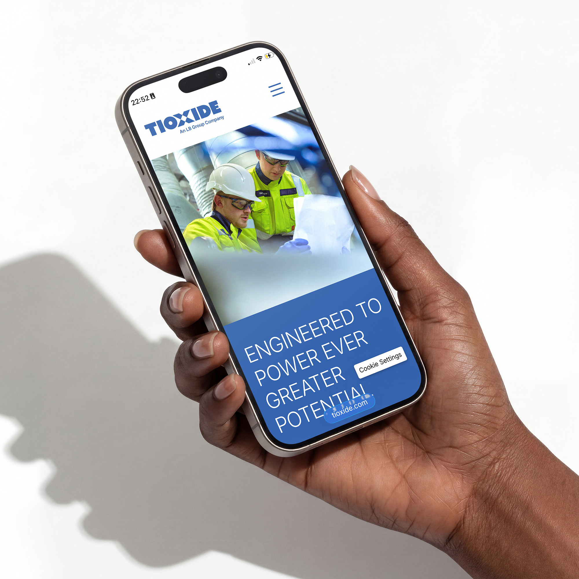 New Tioxide website shown on a hand held mobile phone against a white background. It leads with the new bold brand photography of their team members working.