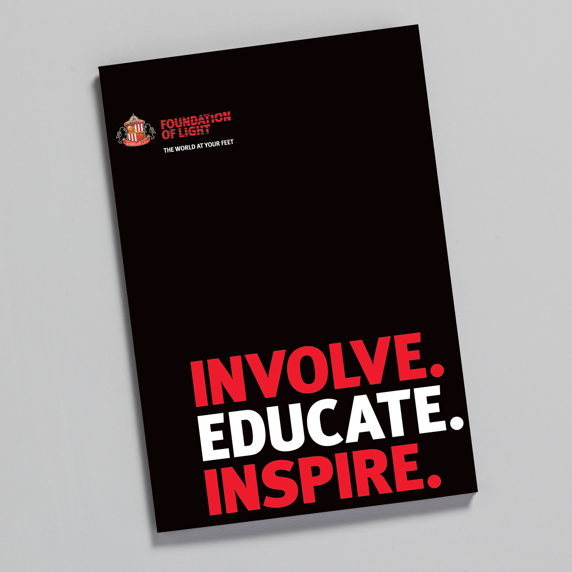 Front cover of a corporate folder cover which is black with red and white lettering; Involve, educate, Inspire
