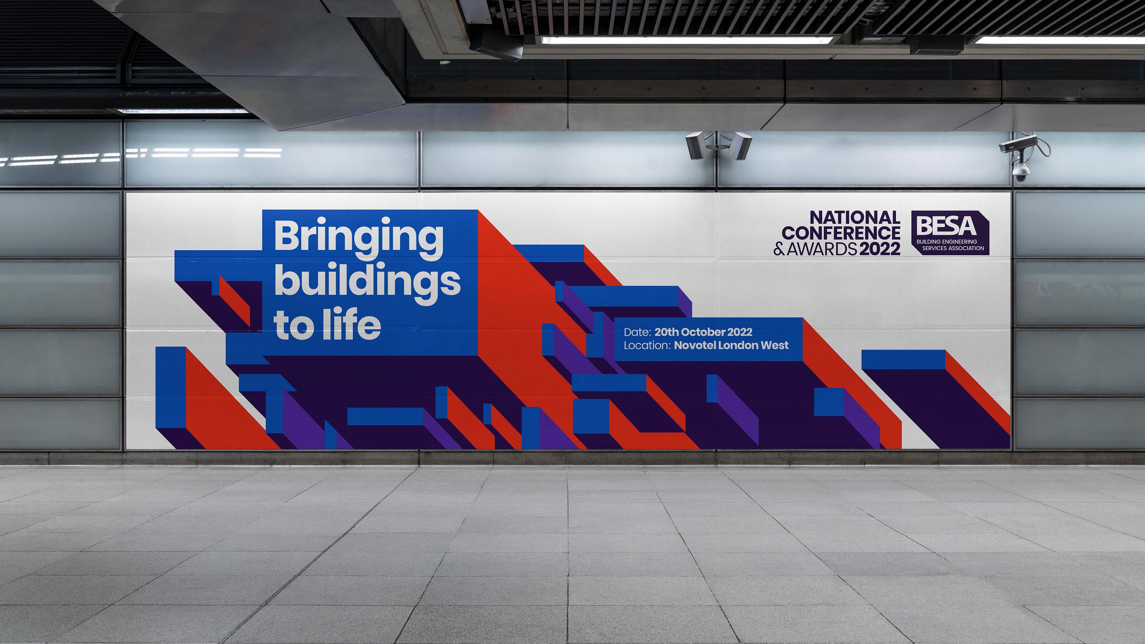 Modern public conference area with large graphic poster promoting the BESA national conference.