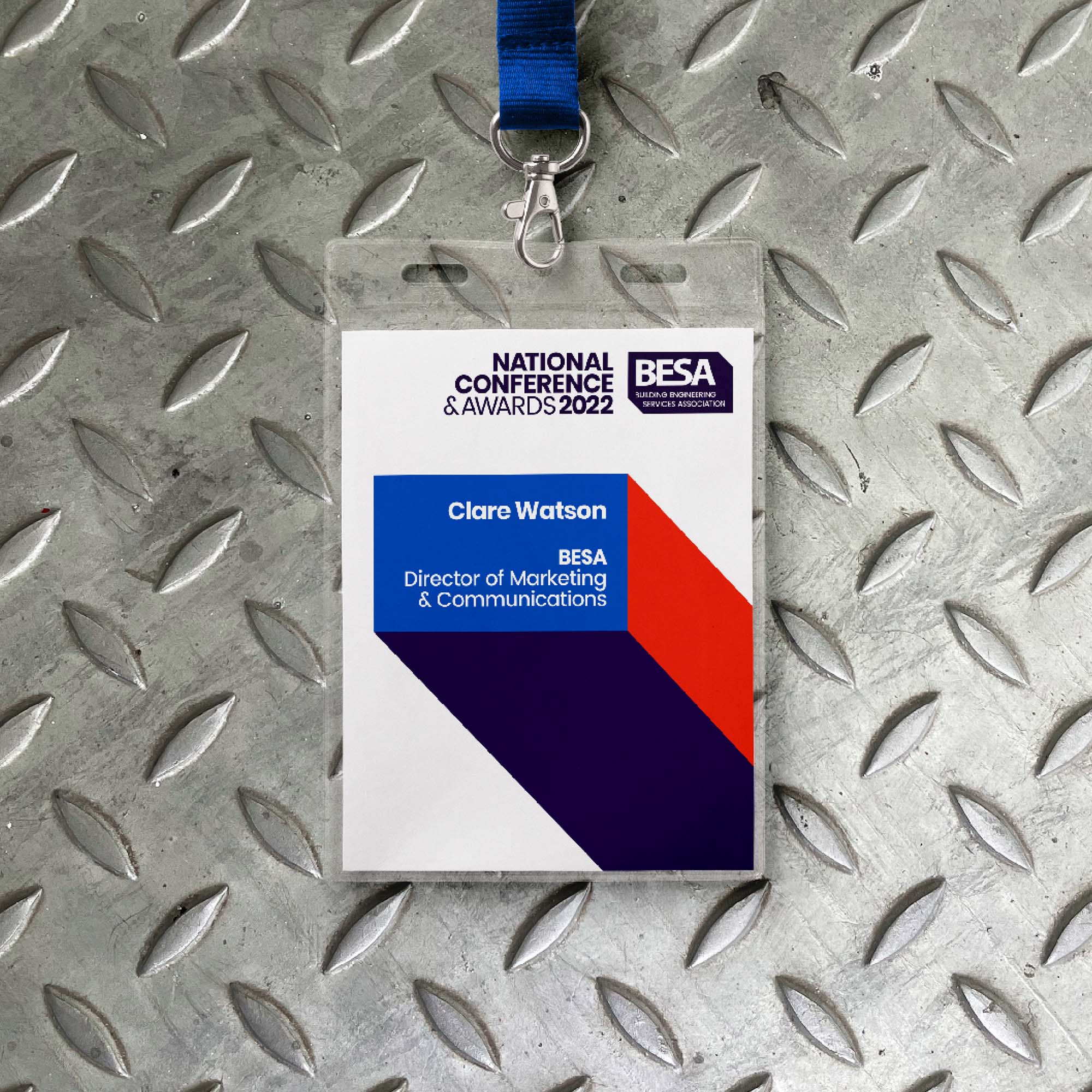 BESA conference lanyard on metal grip tread background.