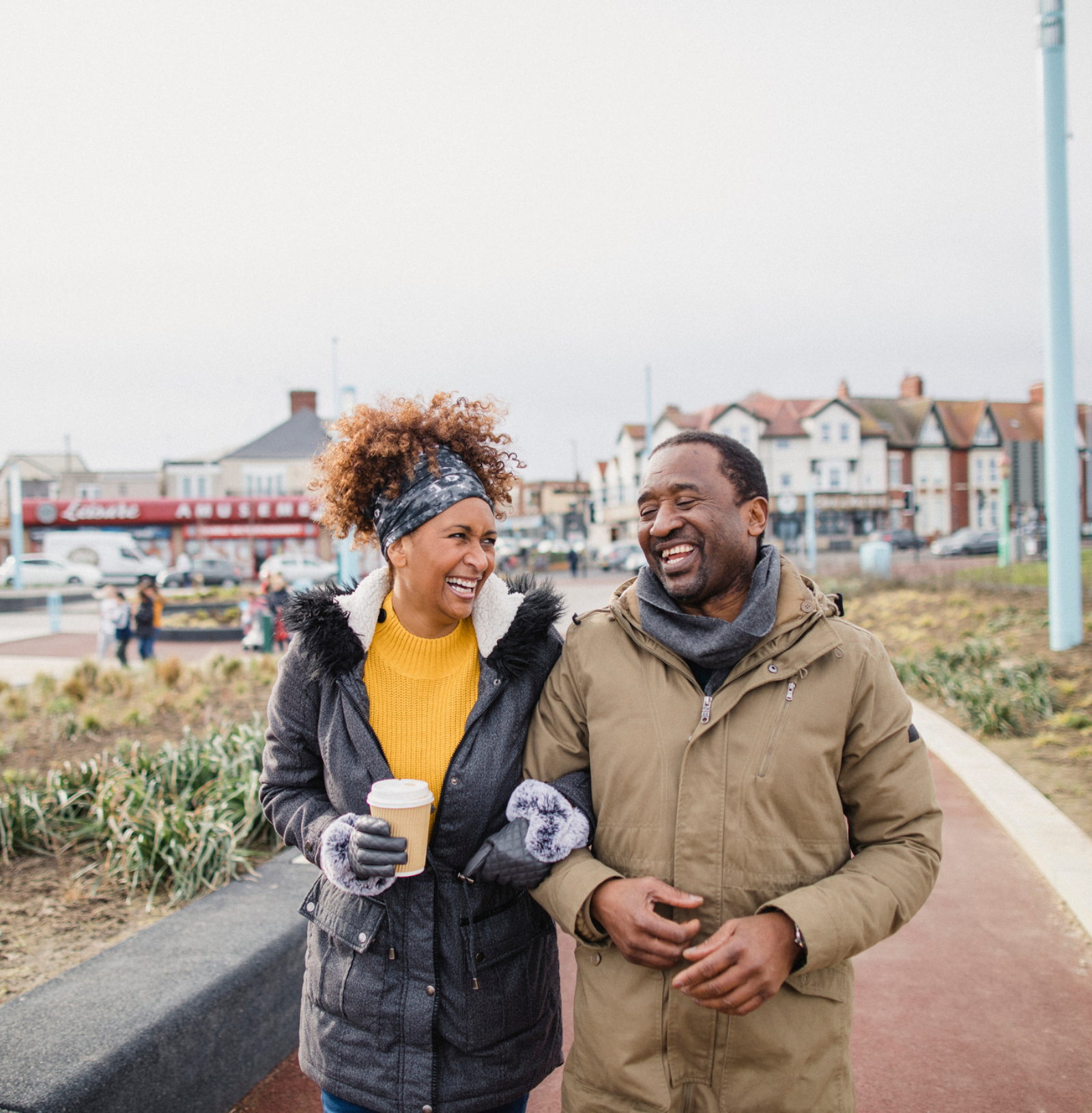 A man and a woman walking arm in arm and laughing