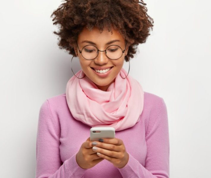 Woman smiling at her cell phone