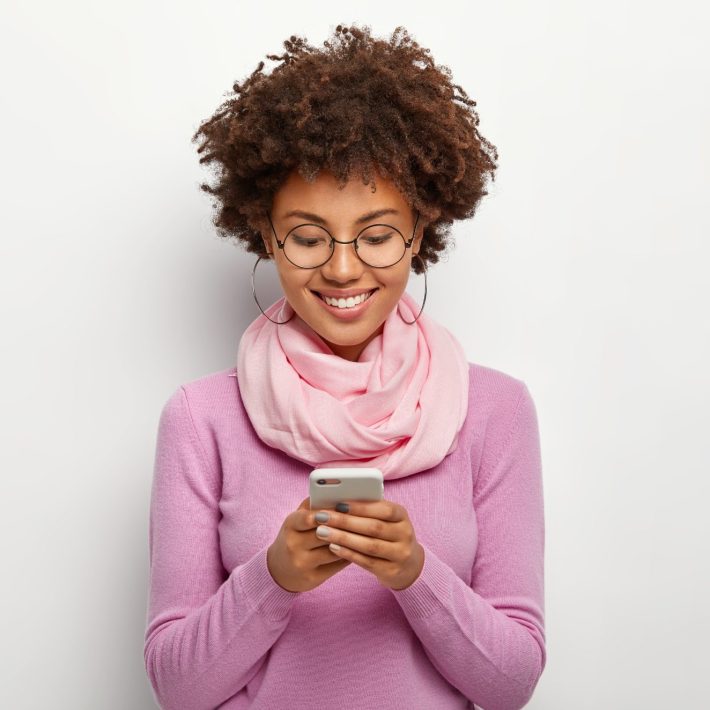 Woman smiling at her cell phone