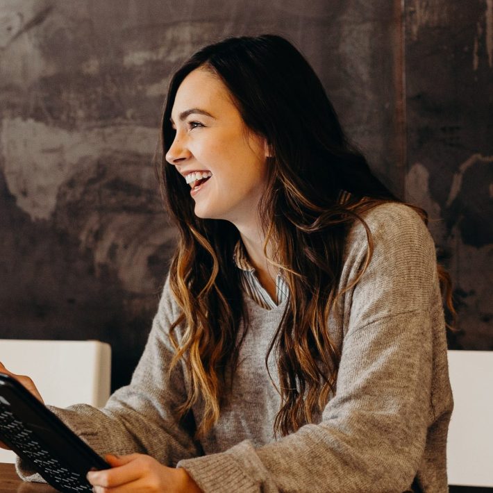 Woman smiling and using device